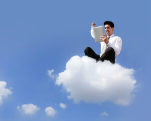 business man sitting on a cloud working with tablet pc